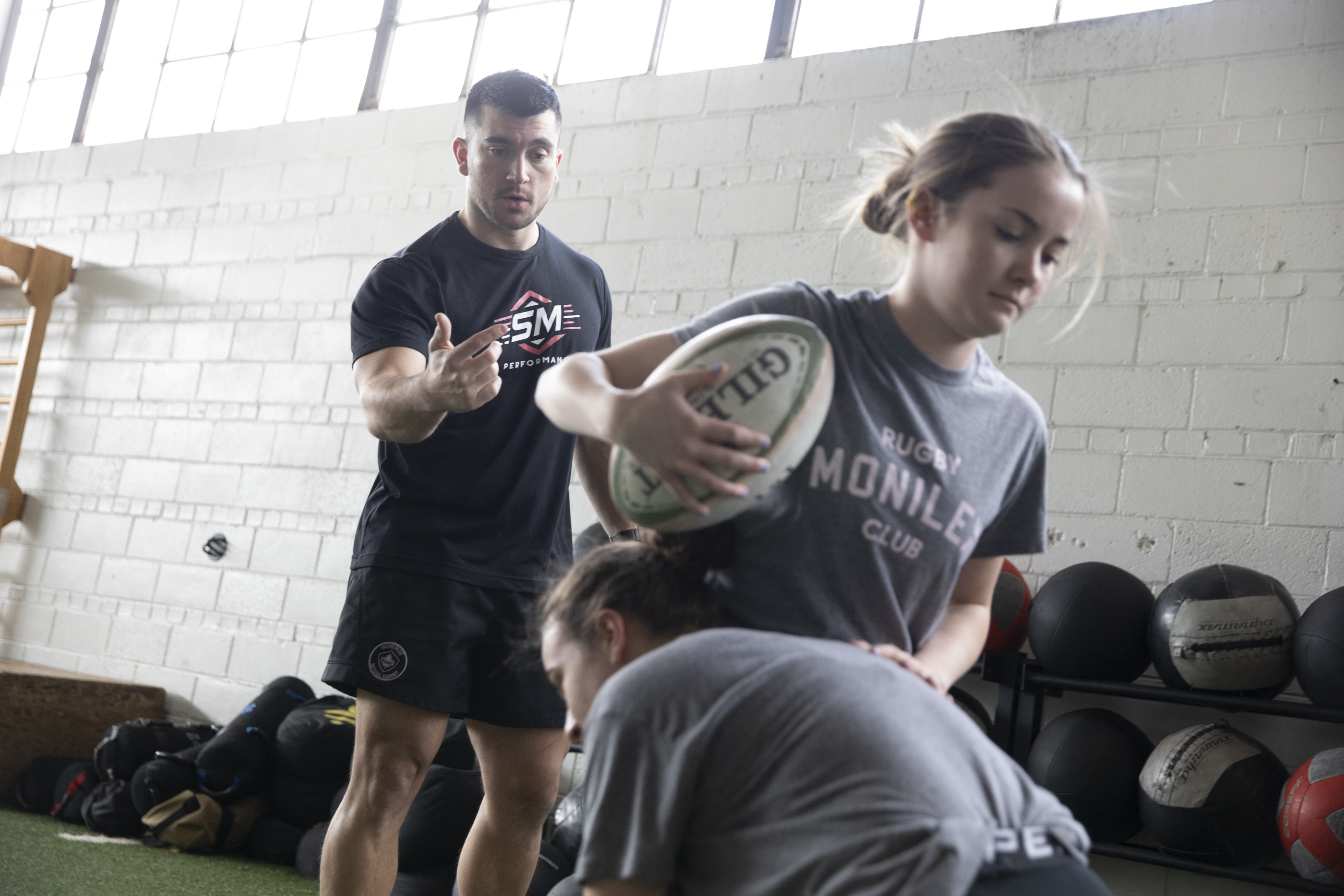 A coach observing practice and giving feedback to athletes