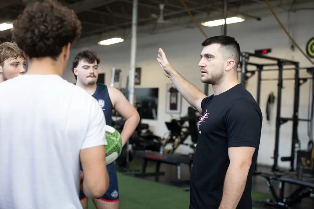 A coach explaining a concept to a group of athletes